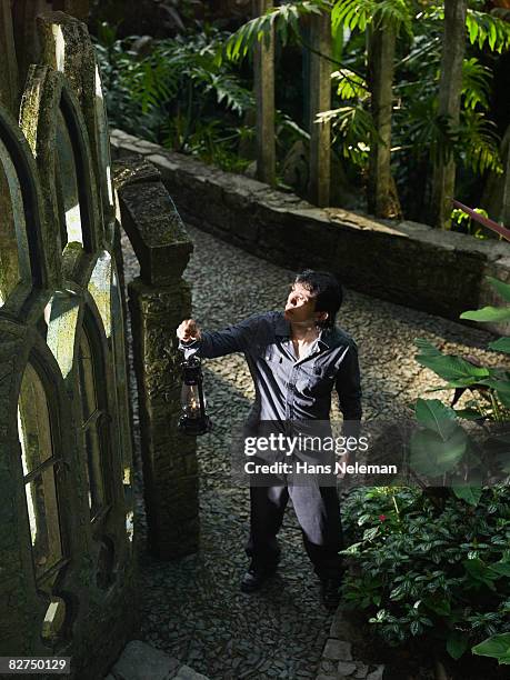 man with a lantern inspecting a gate - las posas foto e immagini stock