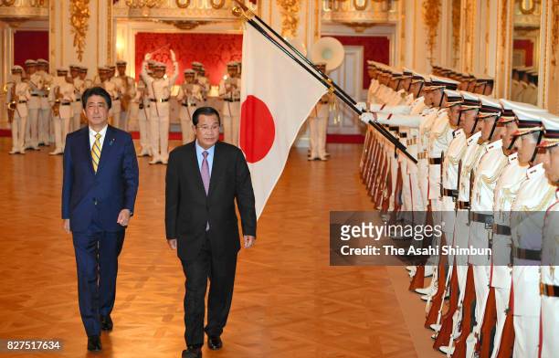 Cambodian Prime Minister Hun Sen reviews the honour guard with Japanese Prime Minister Shinzo Abe during the welcome ceremony at the Asakasa State...