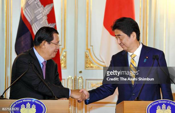 Cambodian Prime Minister Hun Sen and Japanese Prime Minister Shinzo Abe shake hands during a joint press conference following their meeting at the...
