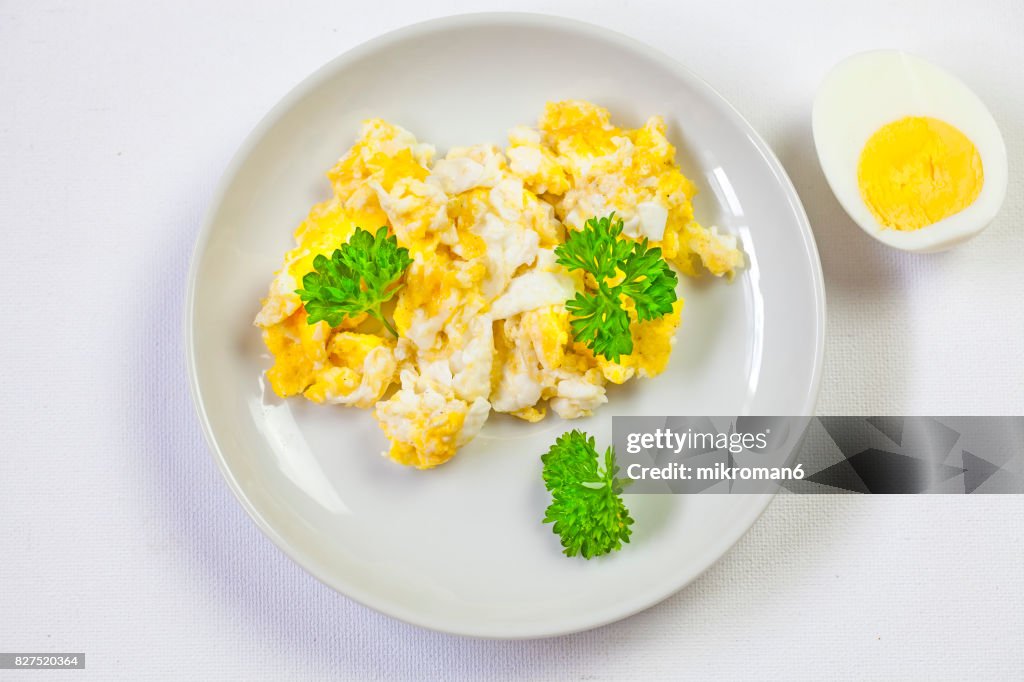 Scrambled eggs On white plate and hard-boiled egg