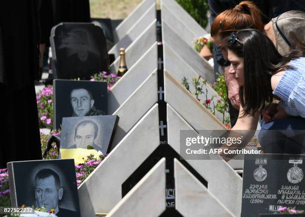 Relatives of Georgia's servicemen killed during the 2008 brief war with Russia over the breakaway region of South Ossetia mourn during a ceremony at...