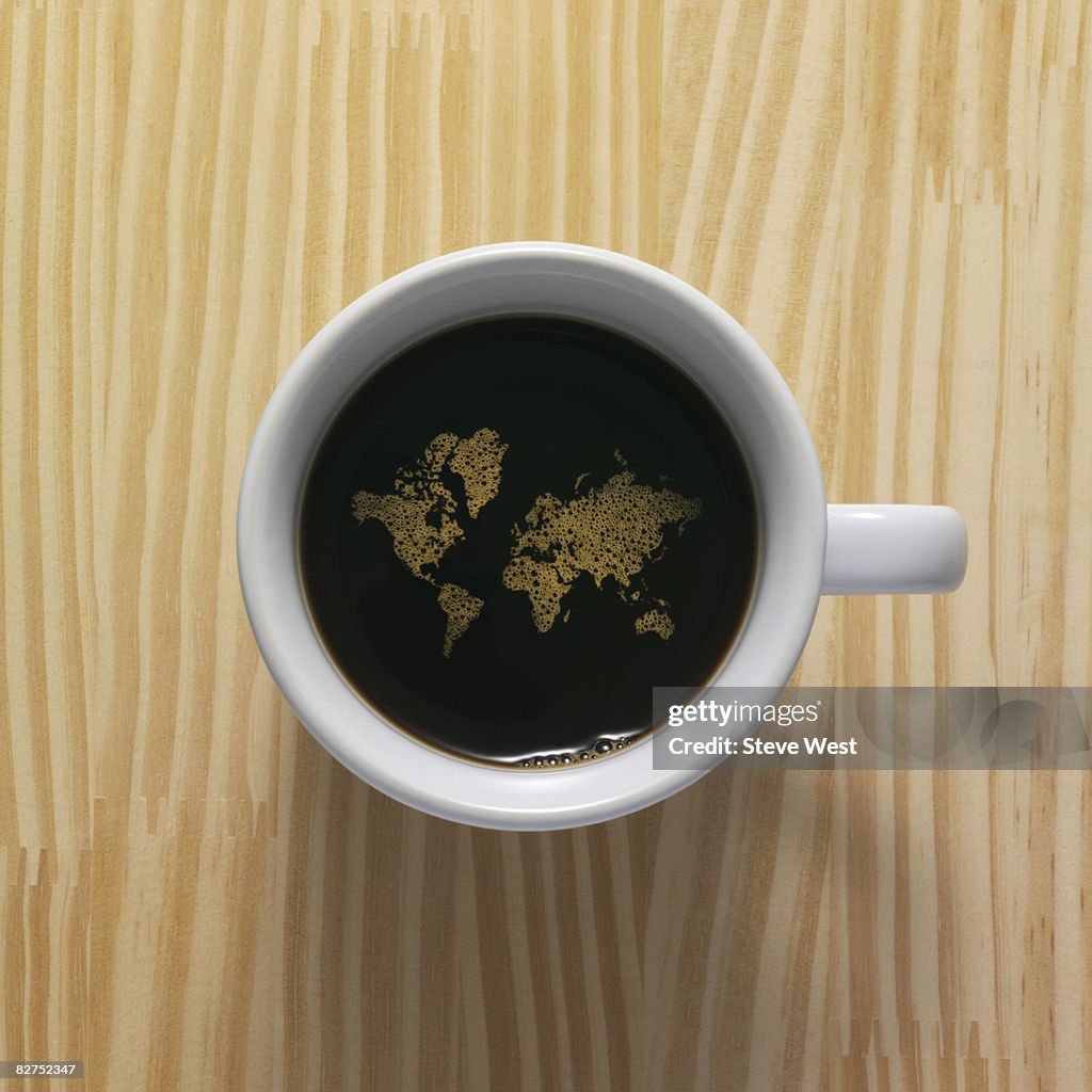 Coffee cup with world map composed of bubbles