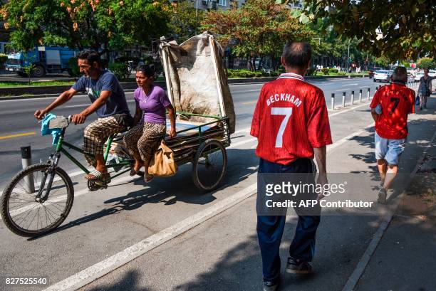 Men wearing old Manchester United jerseys walk in the city of Skopje on August 8, 2017 ahead of the UEFA Super Cup football match between Real Madrid...