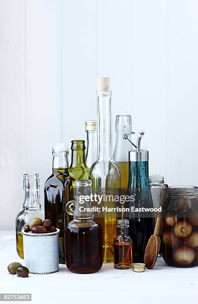 selection of oils and vinegars on kitchen table - vinegar stock pictures, royalty-free photos & images
