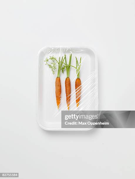 three baby carrots encased in plastic wrapping - polythene stock pictures, royalty-free photos & images