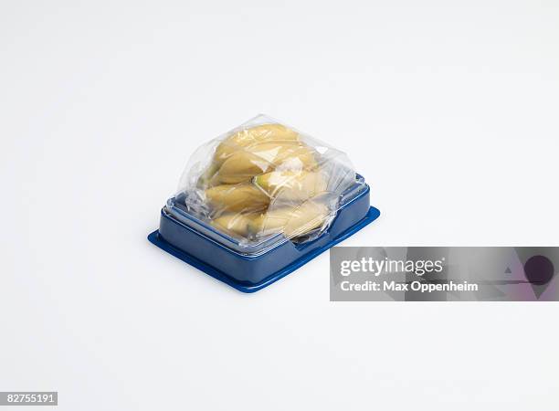 small bananas encased in plastic container - plastic container stock-fotos und bilder