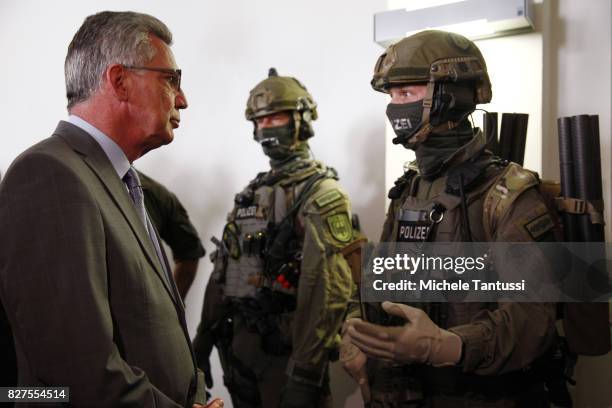 German Interior Minister Thomas de Maziere speaks with officiers of the Police special forces or GSG9 during the opening of the new Headquarters on...