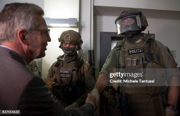 German Interior Minister Thomas de Maziere speaks with officiers of the Police special forces or GSG9 during the opening of the new Headquarters on...