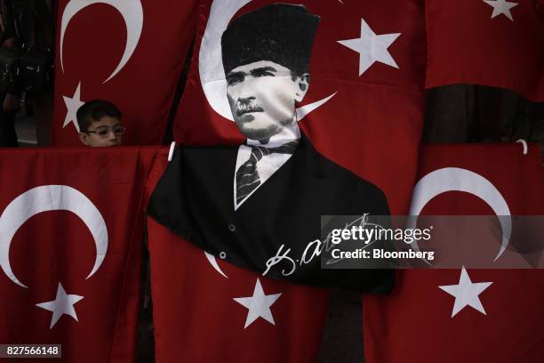 Child stands behind a Turkish flag decorated with the image of Kemal Ataturk, founder of the Turkish republic, in the Sultanahmet district of...