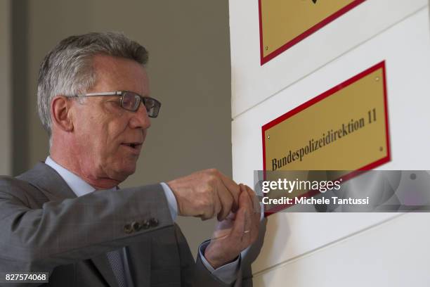 German Interior Minister Thomas de Maziere secures a door sign reading Bundespolizei or Federal Police during the opening of the new Headquarters on...