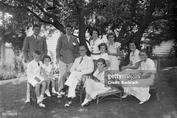 Portrait of the Kennedy family as they sit in the shade of some trees, Hyannis, Massachussetts, 1930s. Seated from left, Robert Kennedy , Edward...