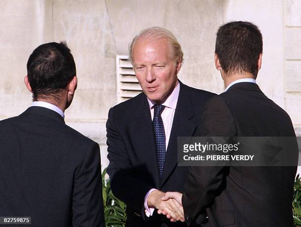 French immigration minister Brice Hortefeux shakes hands with people in front of the city hall in Neuilly-sur-Seine, outside Paris, on September 10...
