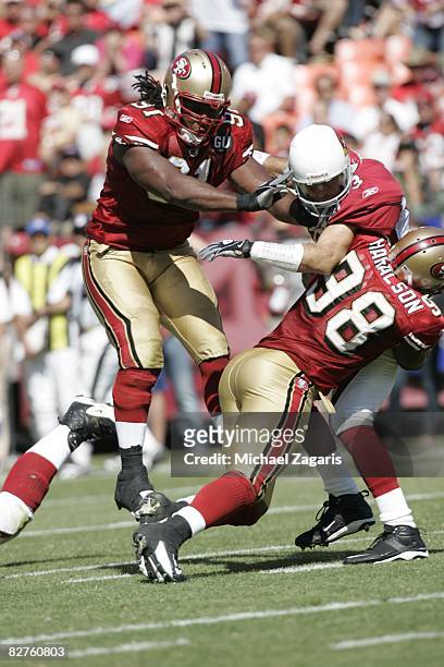 Linebacker Parys Haralson and defensive end Ray McDonald of the San Francisco 49ers sack quarterback Kurt Warner of the Arizona Cardinals during an...