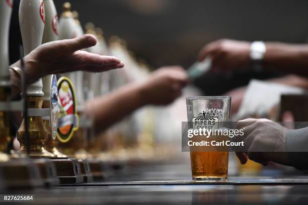 Bar staff serve visitors at the CAMRA Great British Beer festival at Olympia exhibition centre on August 8, 2017 in London, England. The five day...