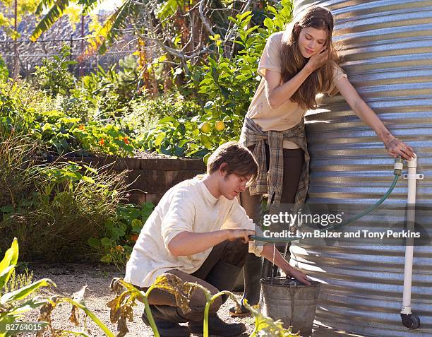 teens filling up water bucket at water tank - water tower storage tank stock pictures, royalty-free photos & images