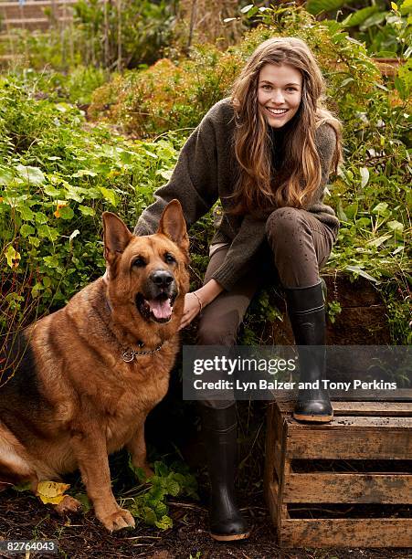 female with a dog in the garden - girl wearing boots stock-fotos und bilder