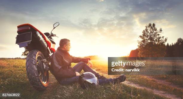 man having rest in the countryside during motorbike trip - moto imagens e fotografias de stock