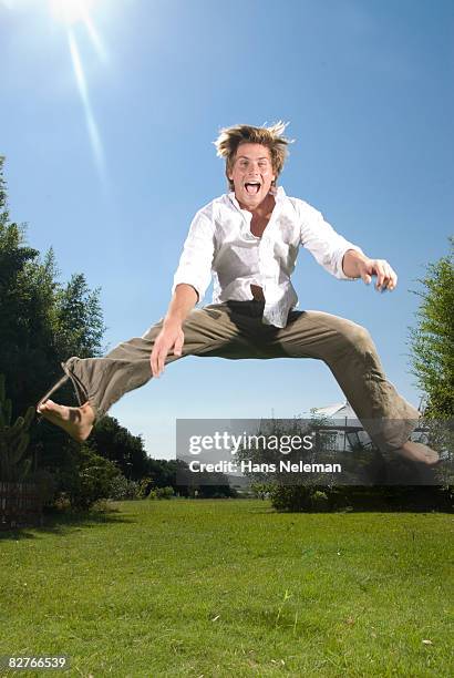 young man jumping - legs apart imagens e fotografias de stock