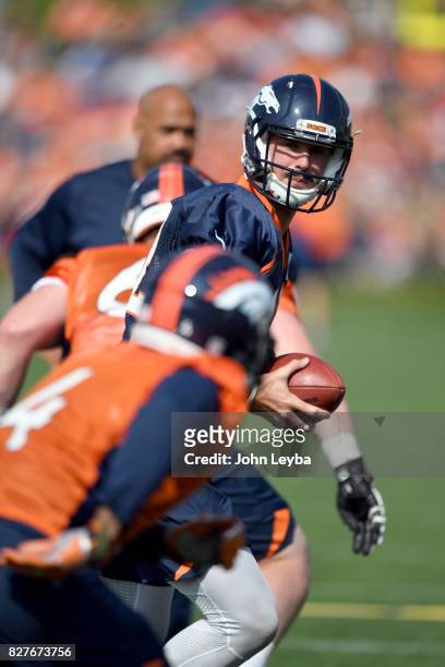 Denver Broncos quarterback Paxton Lynch turns to hand off to Denver Broncos running back Stevan Ridley in practice during training camp on August 8,...