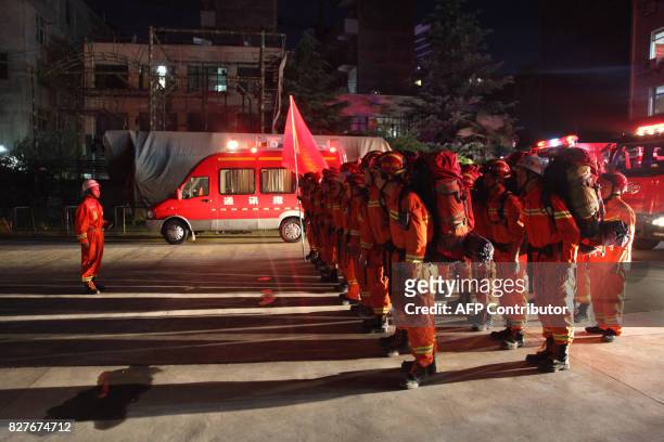 Firefighters stand to attention in Longnan, in China's Gansu province on August 8 as they prepare to head to Wenxian county after an earthquake...