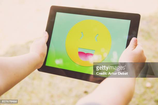 little girl playing with digital tablet and colorful emoticon displayed on the screen from personal perspective. - child with tablet stock pictures, royalty-free photos & images