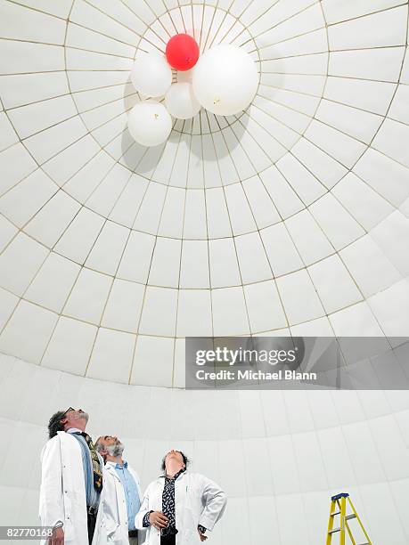 scientist looking upwards at balloons - weather balloon stock pictures, royalty-free photos & images