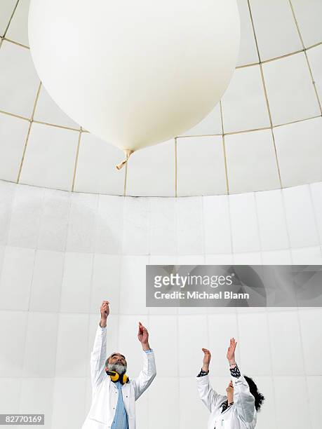 scientist watch balloon float away - weather balloon stock pictures, royalty-free photos & images