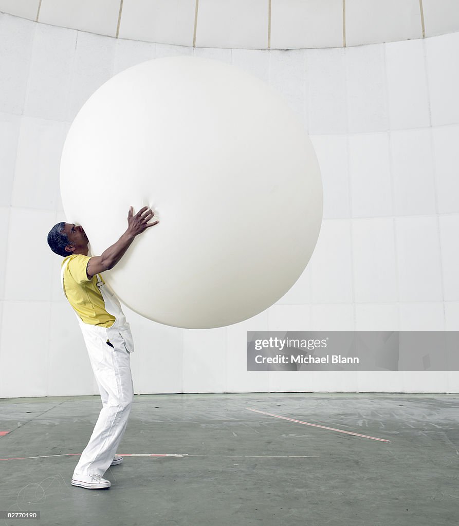 Hombre que agarra un enorme globo