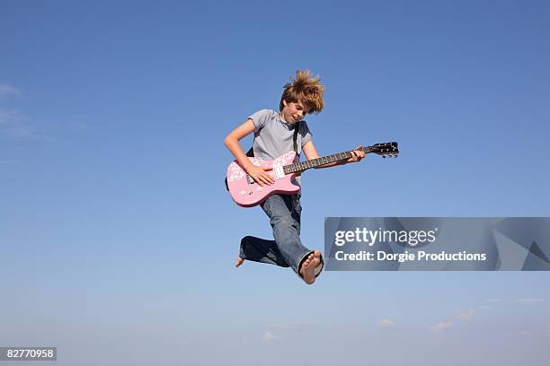 jumping boy rocker with guitar - playing electric guitar stock-fotos und bilder