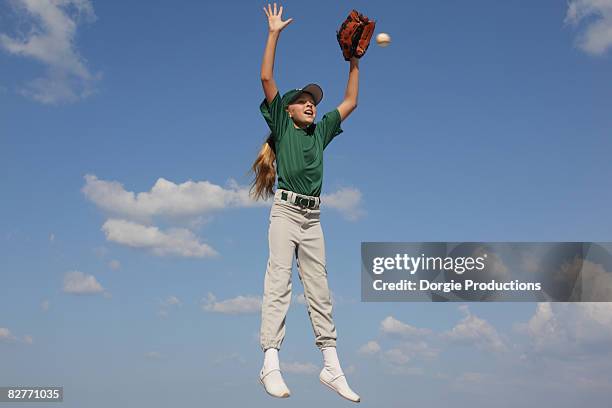 jumping girl catching a baseball mid air - girl reaching stock pictures, royalty-free photos & images