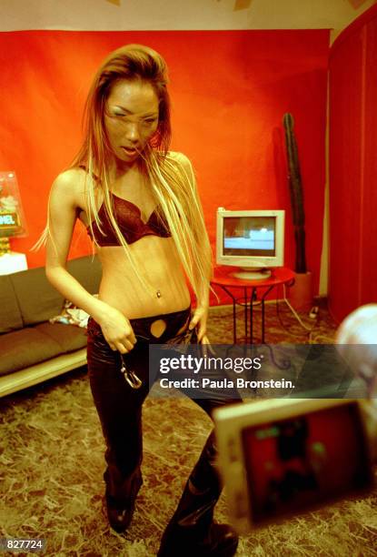 Ebony undresses in front of the digicam in the studio of Enterchannel in Seoul, South Korea, February 2000. She is featured live on the internet and...