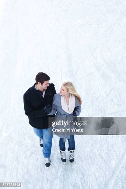 heureux jeune romantique couple patinage sur glace hiver - pardessus photos et images de collection