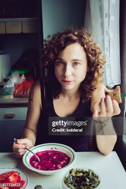 woman eating traditional ukrainian borscht soup at her mother kitchen - borsch stock pictures, royalty-free photos & images