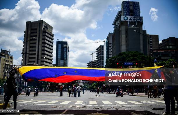 Anti-government activists demonstrate against Venezuelan President Nicolas Maduro at a barricade set up on a road in Caracas on August 8, 2017. -...