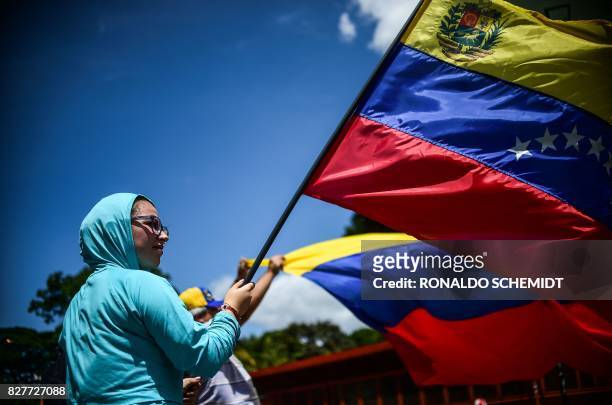 An anti-government activist demonstrates against Venezuelan President Nicolas Maduro at a barricade set up on a road in Caracas on August 8, 2017. -...