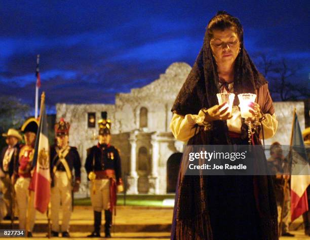 Actors, portraying defenders of the Alamo, hold a candle light vigil in front of the building during a re-enactment of the fall of the Alamo, March 6...