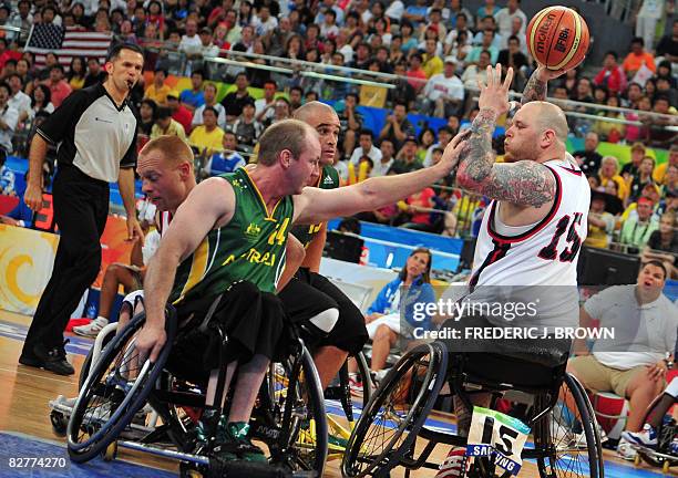 Joe Chambers of the US looks to pass under pressure from Australia's Brendan Dowler and Brad Ness in their men's wheelchair basketball game at the...