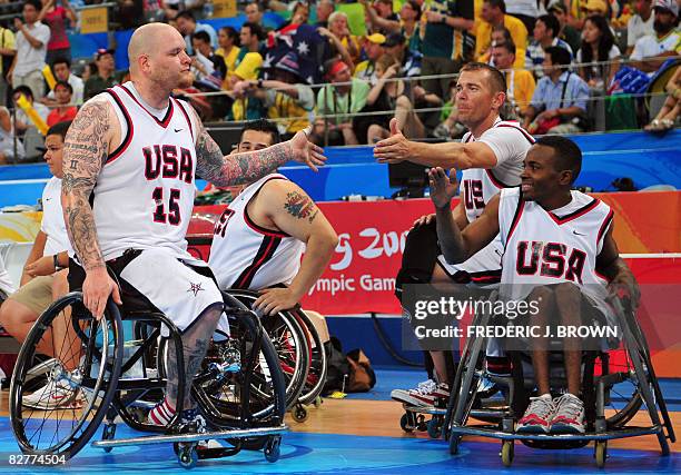 Joe Chambers of the US high-fives teammates Steve Serio and Eric Barber upon heading to the sideline late in the game against Australia in their...