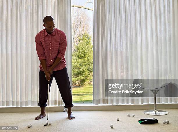 man putting golfballs indoors - golf short iron stock pictures, royalty-free photos & images