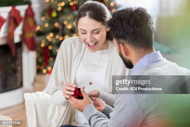 young woman is surprised as her boyfriend proposes to her - caixa de joias imagens e fotografias de stock