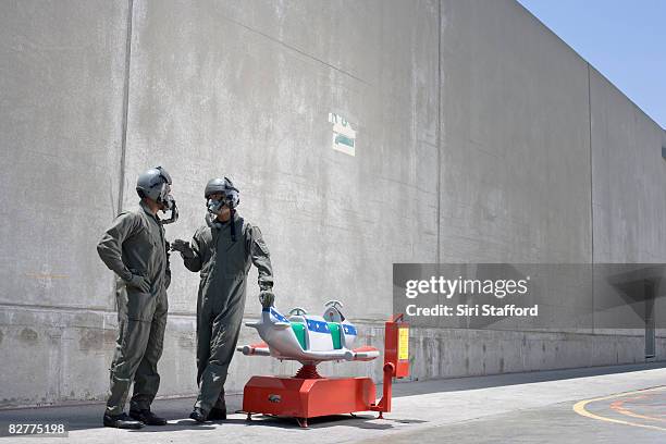 men in fighter pilot suits next to toy jet - people in military uniform stock pictures, royalty-free photos & images