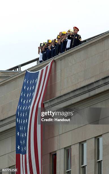 In this handout image provided by the U.S. Department of Defense, first responders stand atop the Pentagon during the Pentagon Memorial dedication...