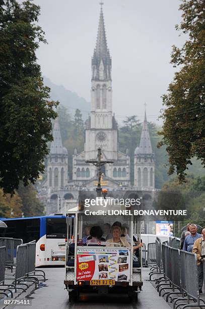 Pilgrims ride a little train infront of the Basilica of the Rosary on September 11, 2008 in Lourdes ahead of the visit of Pope Benedict XVI who will...