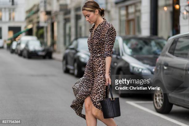 Guest wearing a bucket bag, dress with leopard print, silver heeled boots outside Designers Nest on August 8, 2017 in Copenhagen, Denmark.