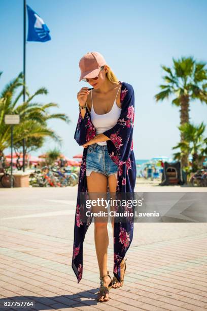 Model Olga de Mar wears Parfois pink hat, Sweet Deluxe bracelet, Brandy Melville white body, Levis jeans short and Baldan "nshoes, on August 6, 2017...