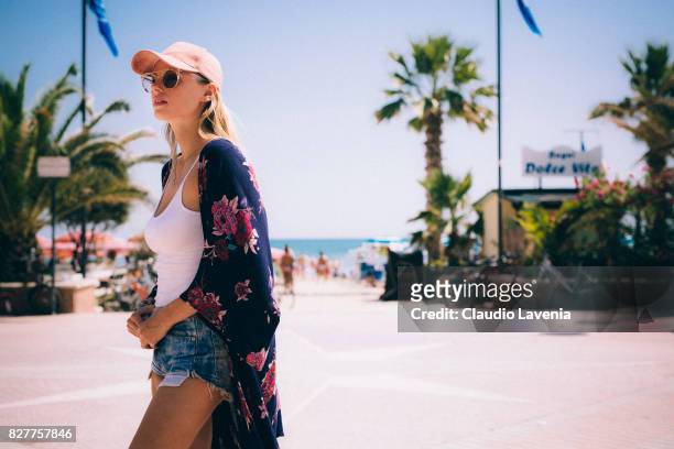 Model Olga de Mar wears Parfois pink hat, Sweet Deluxe bracelet, Brandy Melville white body, Levis jeans short and Baldan "nshoes, on August 6, 2017...