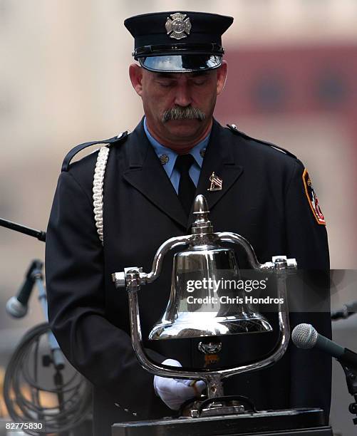 Firefighter stands by a bell after ringing it to mark the 9:03 am crash of United Airlines Flight 175 against the South Tower of the World Trade...