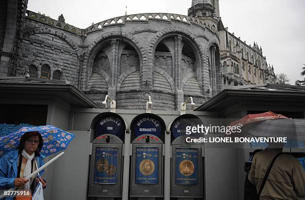 Pilgrims stand by donation machines at the Sanctuary of Lourdes on September 11, 2008 ahead of the visit of Pope Benedict XVI who will commemorate...