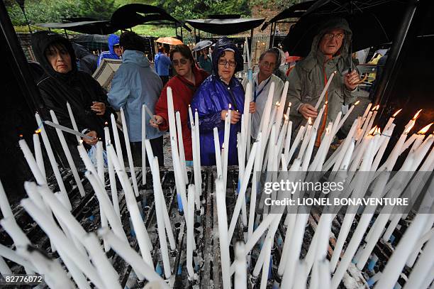 Pilgrims light candles near the Grotto of Massbielle at the Sanctuary of Lourdes on September 11, 2008 ahead of the visit of Pope Benedict XVI who...