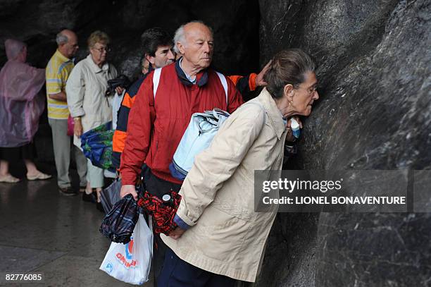 Pilgrims pray at the Grotto of Massbielle at the Sanctuary of Lourdes on September 11, 2008 ahead of the visit of Pope Benedict XVI who will...